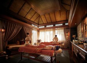 a hotel room with two beds and a woman sitting on the bed at Shangri-La Tanjung Aru, Kota Kinabalu in Kota Kinabalu