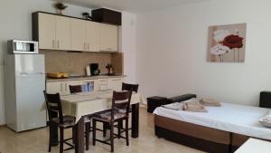 a kitchen and dining room with a table and chairs at GENIKO Apartments in Pomorie