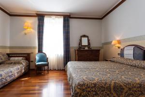 A bed or beds in a room at Albergo Il Cacciatore