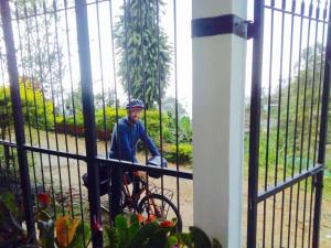 a man riding a bike next to a fence at Farah Guest Inn in Haputale