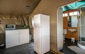 a kitchen with a white refrigerator and a sink at West Coast Luxury Tents in Dwarskersbos