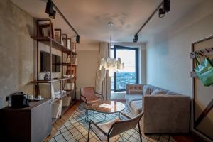 a living room with a couch and a table at 25hours Hotel Das Tour in Düsseldorf