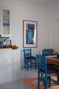 a dining room with blue chairs and a table at Τhe White Houses in Makry Gialos