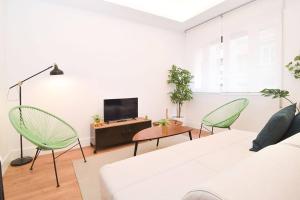 - un salon avec un canapé blanc et 2 fauteuils verts dans l'établissement Beautiful Apartment in Quevedo by Batuecas, à Madrid