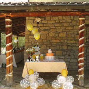 una mesa con un pastel y globos en ella en Agriturismo Terra e Sapori en Campodipietra