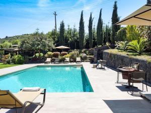 een zwembad in een tuin met stoelen en een tafel bij Belvilla by OYO Viagrande in Trecastagni
