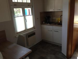 a kitchen with a sink and a window and a table at Bungalow Beachhouse in Boltenhagen +4 photos