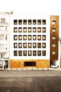 ein großes weißes Gebäude mit Fenstern auf einer Straße in der Unterkunft Square Nine Hotel Belgrade-The Leading Hotels of The World in Belgrad