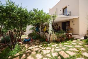 un patio trasero de una casa con árboles y plantas en Timbuktu Hostel, en San Vito lo Capo