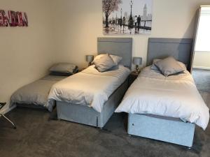 dwa łóżka siedzące obok siebie w pokoju w obiekcie Fornham Guest House w mieście Chertsey