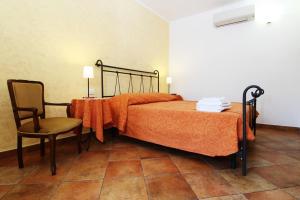 una camera con letto, sedia e tavolo di Agriturismo di Paterno a Sarzana