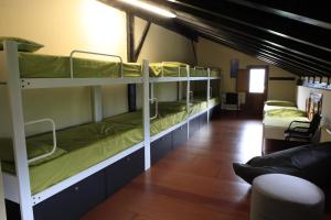 a room with three bunk beds in a room at Albergue Uztartza in Aduna