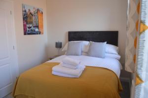a bedroom with a bed with towels on it at Fantastic Hampton Centre Stay in Peterborough