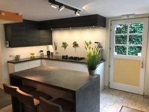 a kitchen with a black counter top and a table at Holiday Home New Largo in Nieuwpoort