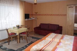 a bedroom with two beds and a table and a couch at Weinfelderhof in Kröv