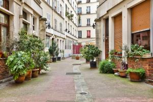 an alley with potted plants on the side of a building at 66 - Atelier Fidélité Paris in Paris