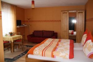 a bedroom with a bed and a living room at Weinfelderhof in Kröv