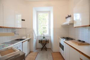 eine Küche mit weißen Geräten und einem Fenster in der Unterkunft Rome Sweet Home near Metro Flaminio in Rom