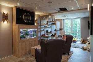 a living room with two chairs and a fish tank at The Hotel Unforgettable - Hotel Tiliana by Homoky Hotels & Spa in Budapest