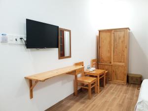 a room with a desk and a tv on a wall at Phú tài center hotel in Phú Thạnh