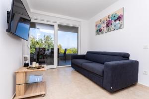 ein Wohnzimmer mit Couch und Fernseher in der Unterkunft Villa Neda in Malinska