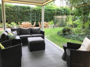 a patio with couches and chairs on a deck at Holiday Home New Largo in Nieuwpoort