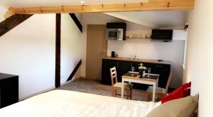 sypialnia z łóżkiem i stołem oraz kuchnia w obiekcie Gîtes du Golf w mieście Sart-Dames-Avelines