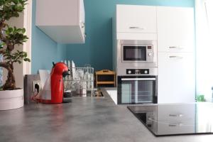 a kitchen with a red animal statue in the middle of it at Les pièces du puzzle in Dunkerque
