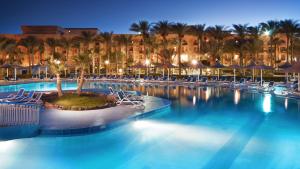 einen Pool in einem Resort mit Stühlen und Palmen in der Unterkunft Giftun Azur Resort in Hurghada