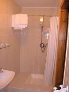 a bathroom with a shower with a tub and a sink at Mountain View Guesthouse in Oughterard