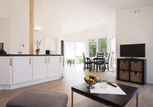 a living room with white cabinets and a table at Ferienhäuser am Hainich in Hörselberg-Hainich