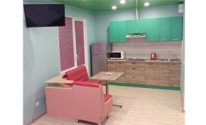 キーウにあるCozy apartments near metro Poznyakiのキッチン(緑のキャビネット、赤い椅子、テーブル付)