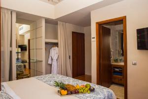 a room with a bed with a bowl of fruit on it at Limeni Inn Boutique Hotel Adults only 12plus in Limeni