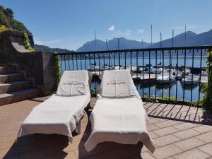 two white beds on a balcony overlooking a marina at Foresteria Lombarda La Spiaggia in Lierna