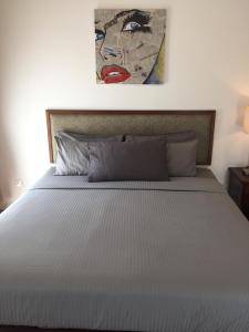 a bed in a bedroom with a painting on the wall at Afiniti Muslim Medini Condo in Nusajaya +39 photos