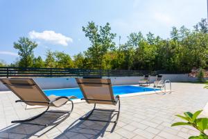 eine Gruppe von Stühlen neben einem Swimmingpool in der Unterkunft Villa Neda in Malinska