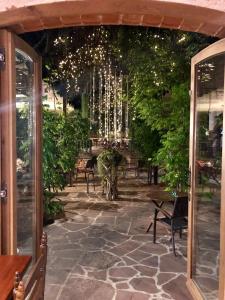 un patio avec des chaises, des arbres et des lumières dans l'établissement Hostal La Guineu, à Viladrau