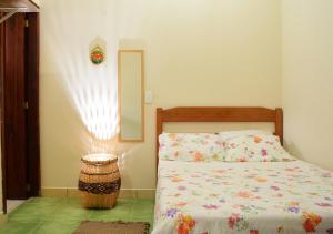 1 dormitorio con cama y espejo en la pared en Trindade Hospeda - Estúdios e Casa Vila Trindade, en Trindade