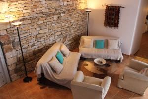 a living room with two chairs and a brick wall at Guesthouse Casa De La Roca , Kostos , Paros in Kóstos