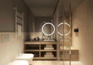 ein Badezimmer mit einem WC, einem Waschbecken und einem Spiegel in der Unterkunft Ròseo Euroterme Wellness Resort in Bagno di Romagna
