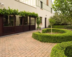 un patio de ladrillo con un árbol frente a un edificio en Manoir thoveke, en Lauwe