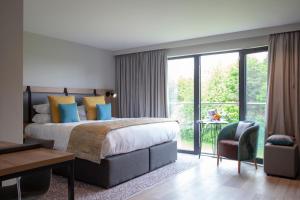 a bedroom with a large bed and a large window at Mercure Newcastle George Washington Hotel Golf & Spa in Newcastle upon Tyne