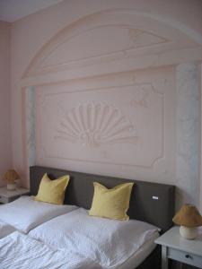 Una cama con dos almohadas amarillas encima. en Villa Utpatel, en Ahlbeck