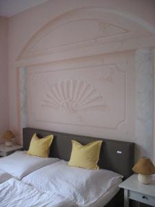 a bed with two yellow pillows on top of it at Villa Utpatel in Ahlbeck