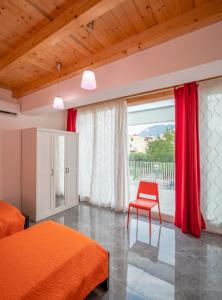 a bedroom with two beds and a red chair at Arricàmpati Apartments Villa & Bringo Car Rental in Carini