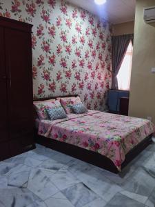 a bedroom with a bed with pink floral wallpaper at Bayan Baru Homestay @ Taman Sri Nibong in George Town
