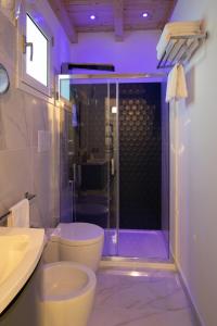a bathroom with a toilet and a shower with purple lighting at Arricàmpati Apartments Villa & Bringo Car Rental in Carini