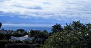 uma vista para o oceano com montanhas à distância em Ocean Life em Plettenberg Bay
