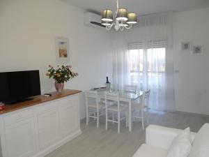 a living room with a dining table and a television at Appartamento vista mare in Martinsicuro