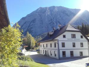 a large white building with a mountain in the background at Egghartguthütte in Tauplitz